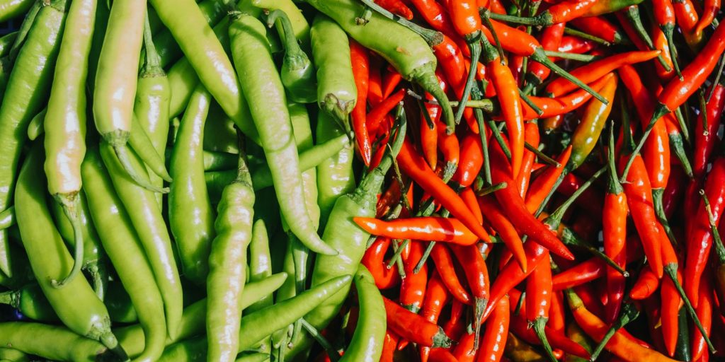 Close up top view of green chillies next to red chillies