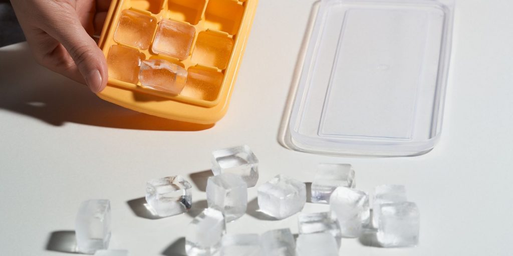 Close up of a person making clear ice cubes in a tray