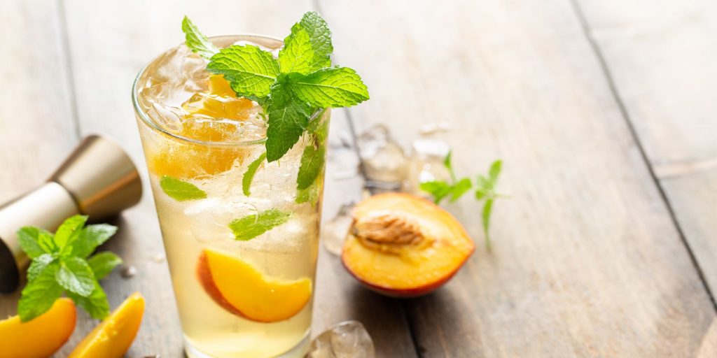 Close up top shot of a refreshing Peach Mojito garnished with fresh mint