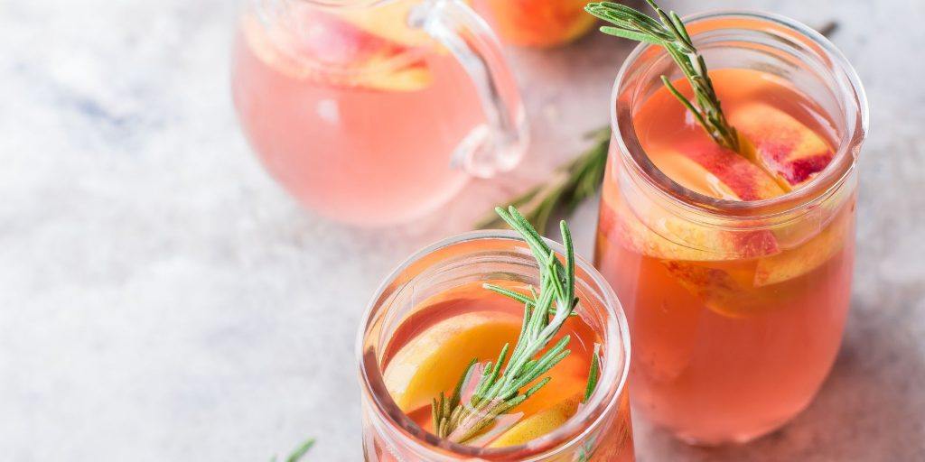 Close up top view of two Bourbon Peach Smash cocktails in drinking jars