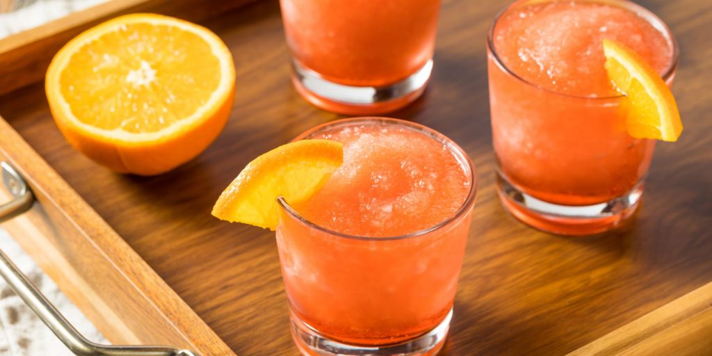 Close up of a trio of Frozen Sangria Slushies on a wooden tray