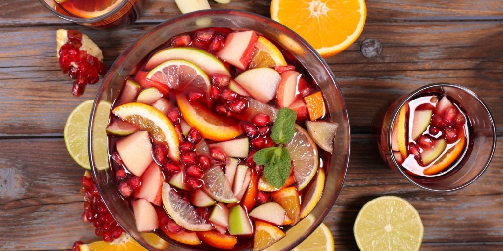 Close up top view of a Pomegranate Champagne Punch filled with colorful slices of fruit