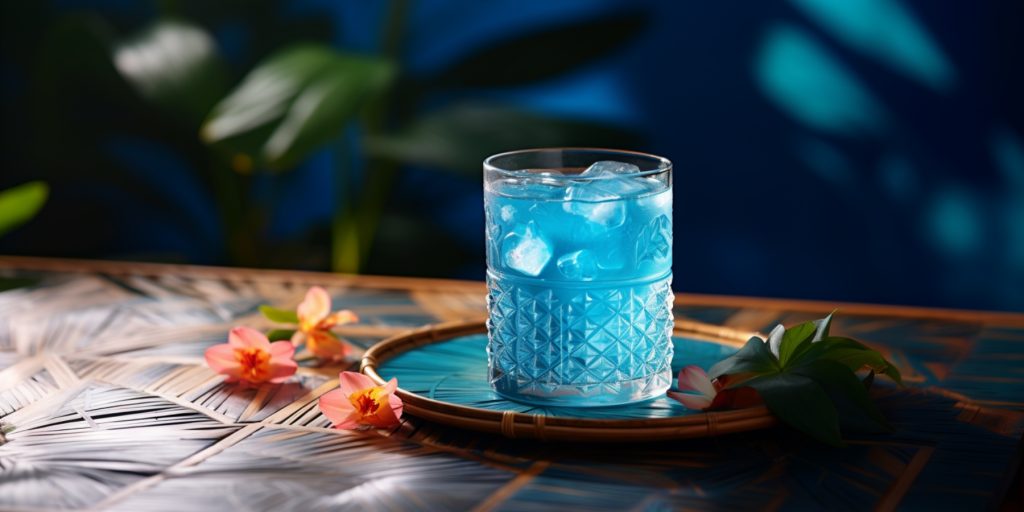 Blue Hawaiian cocktail on a table in a lush outdoor courtyard environment