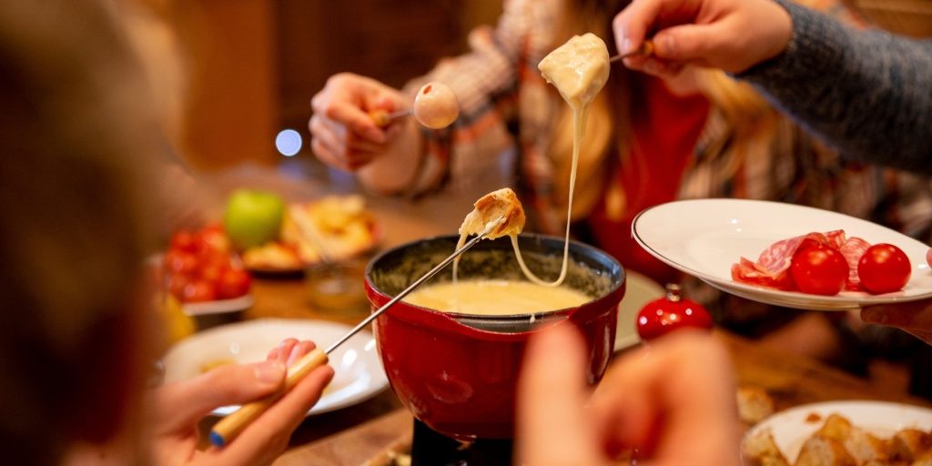 Close-up of a groupd of friends enjoying a classic 1970s breakfast fondue