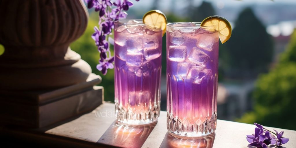 Editorial style image of two Simple Color-Changing Magic Lemonade cocktails on a table outside on a veranda with a purple Wisteria in full bloom