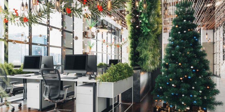 Christmas party decorations set up in a bright, light modern office space, including a big tree