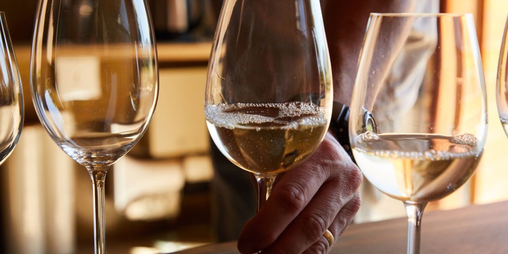 Close up image of a line-up of wine tasting glasses filled with different types of white wine