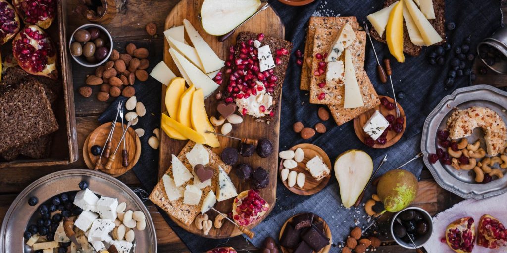  Top view of a luscious fruit and cheese board arranged on a wooden table