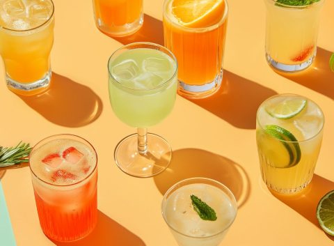 Top view of a selection of vegan cocktails on an orange surface