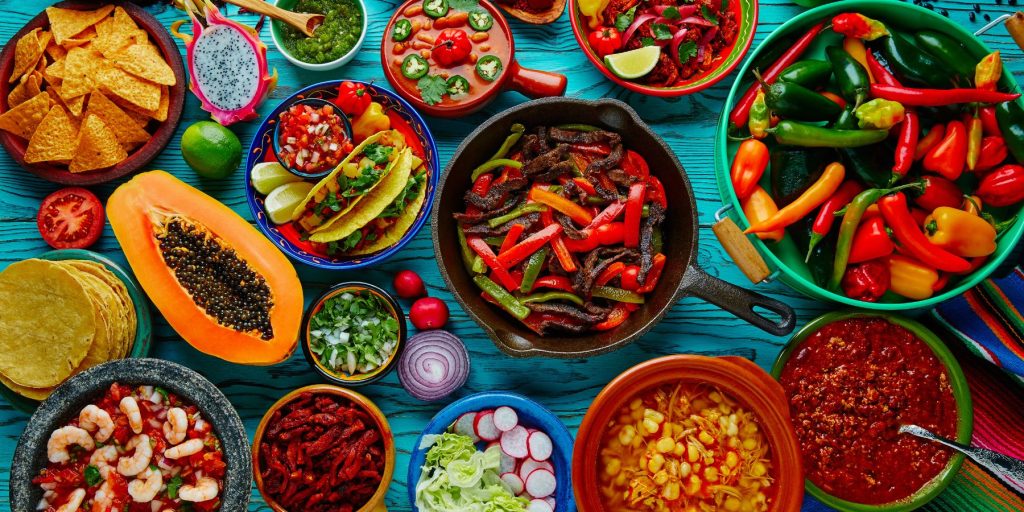 Top view of a variety of Mexican foods contributed by a group of friends for a Cinco de Mayo potluck.