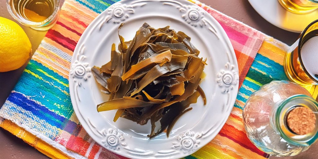 Top view of a plate of kelp on a colourful tablecloth, surrounded by cocktail making ingredients