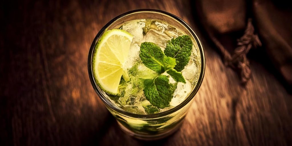 Close-up overhead shot of a Mojito cocktail with fresh lime and mint garnis