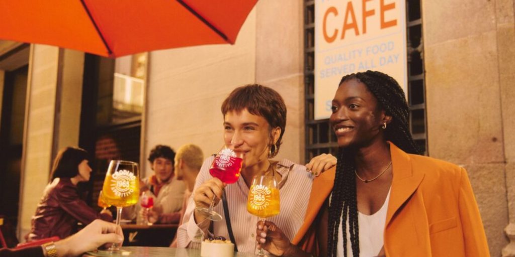 Three friends sitting at an Italian café drinking Crodino