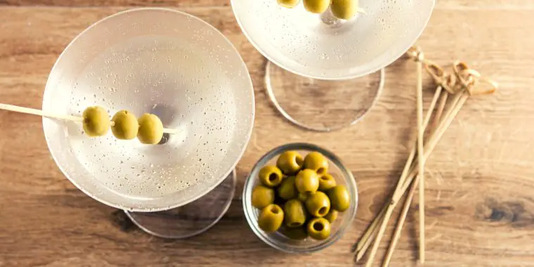 Top view of dry martinis with green olive garnish