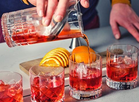 Pouring shot of on the rocks Negroni cocktails