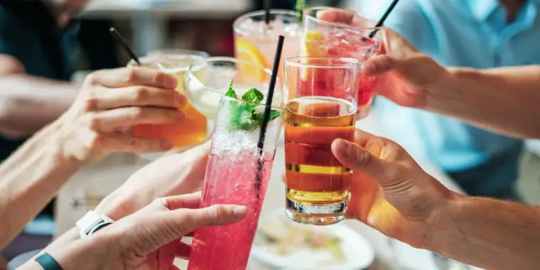 Image of hands raising glasses of 3 ingredient cocktails