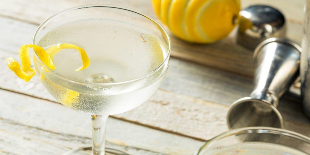 Martini with a twist of lemon on wooden bakground
