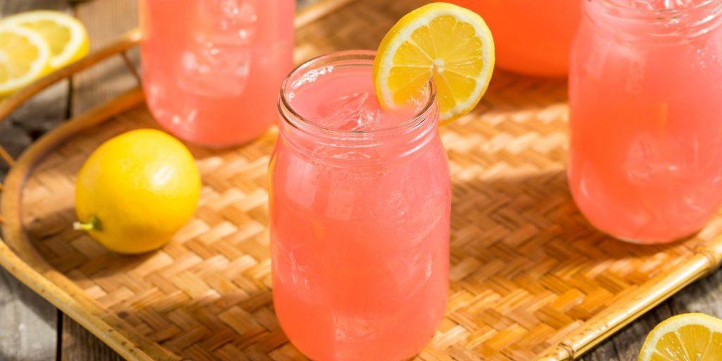 Grapefruit mocktails served in ice-filled jars with a lemon slice garnish