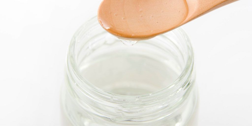 Sugar syrup in a jar with a wooden spoon