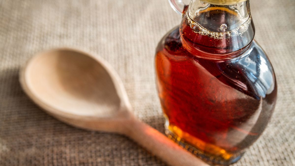 Maple syrup in a jar with a wooden spoon