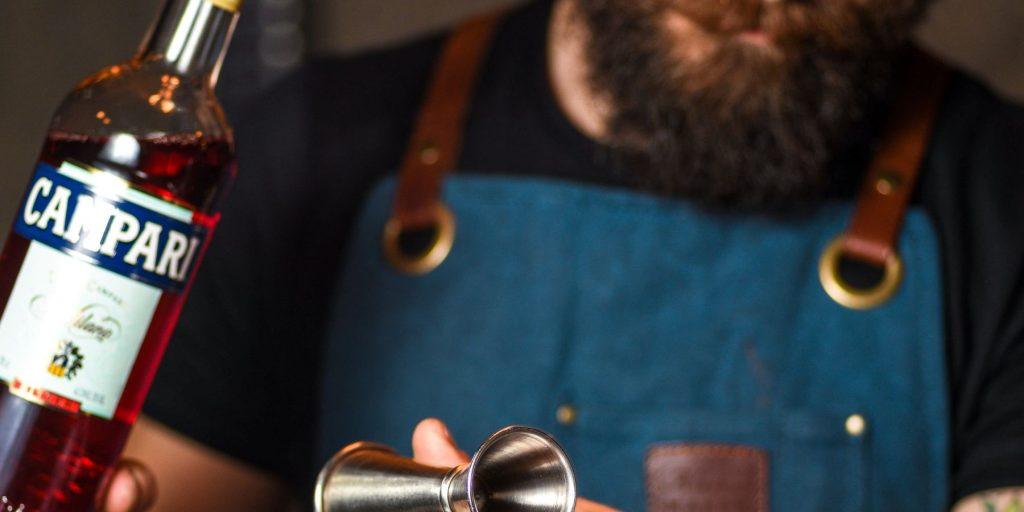 Hipster barman pouring Campari