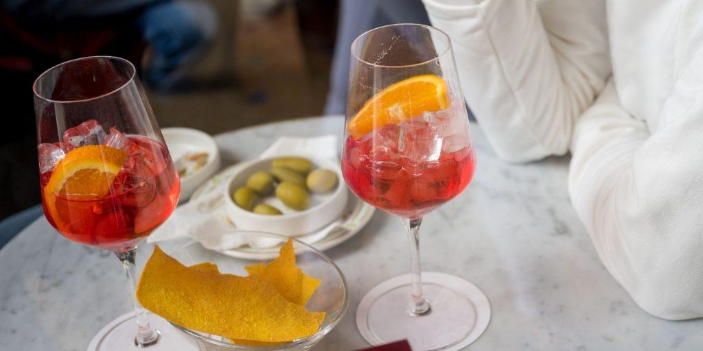 Two people enjoying a campari with olives