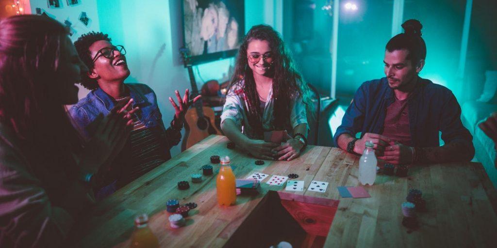 Group of friends drinking and playing poker at a table