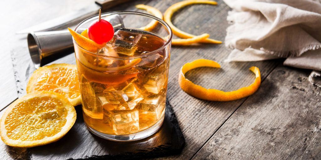 An old fashioned on a wooden surface with orange peel