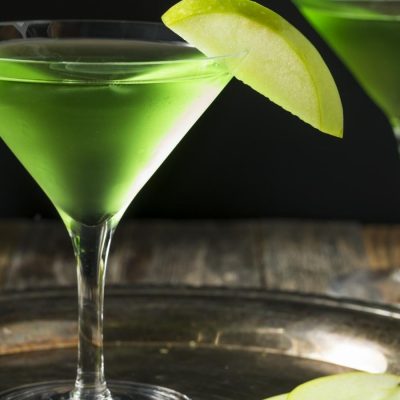 Bright green Apple Martinis with sliced apple garnish
