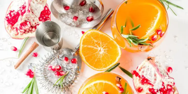 Orange juice cocktails with pomegranate and rosemary