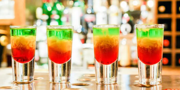 A row of four green, yellow and red Squashed Frog cocktails