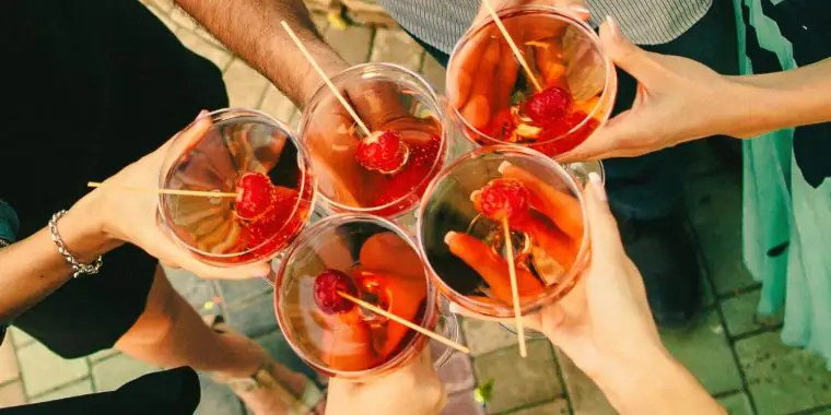 Top shot of friends toasting with strawberry Champagne cocktails