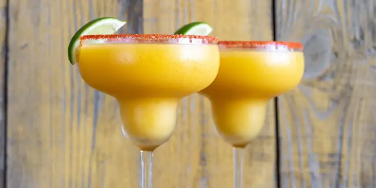 Two frozen mango margaritas in coupe glasses