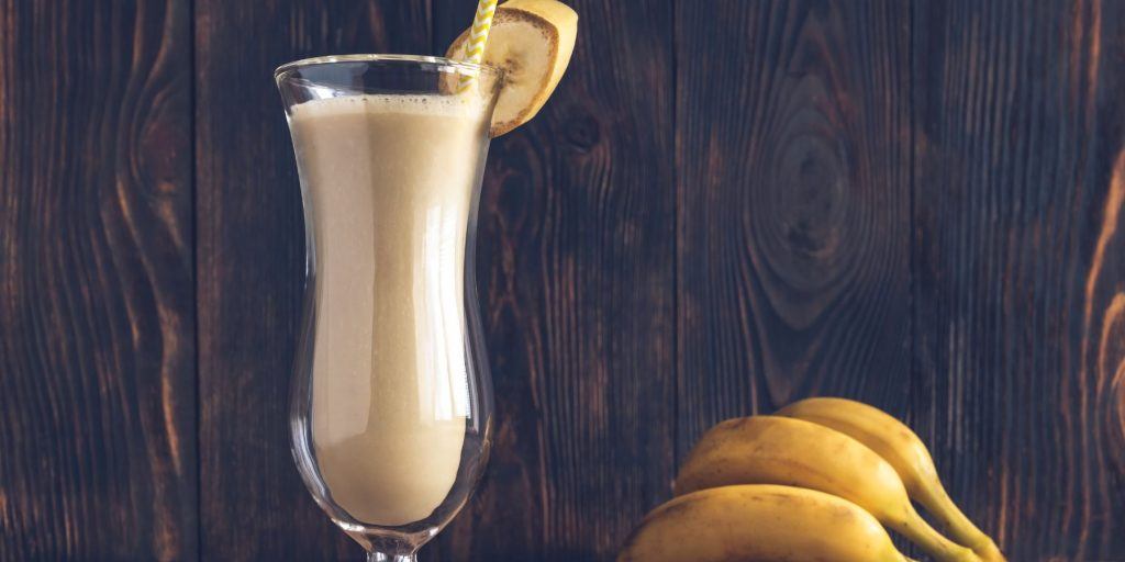 Dirty Banana Cocktail in a hurrican glass with wooden background