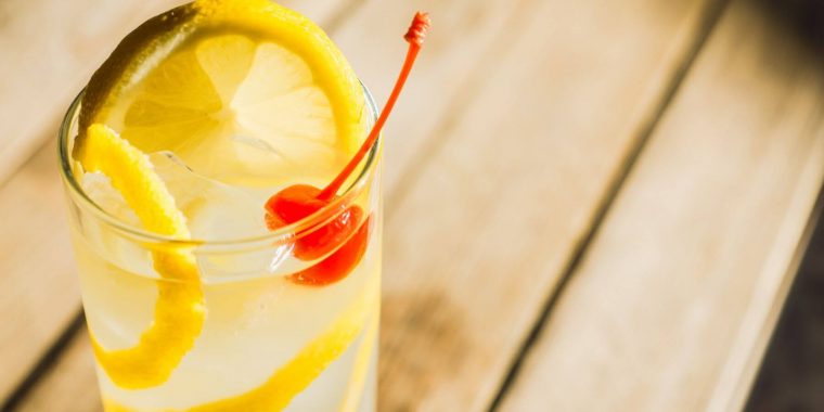 Close up slightly overhead of a Vodka Collis with orange and cherry garnish