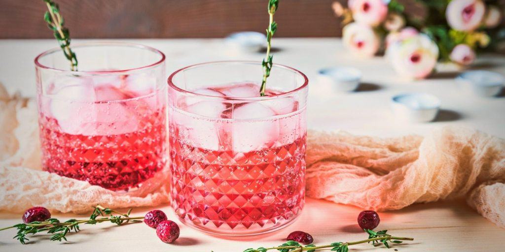 Pink botanical cocktails with rosemary and flower garnish