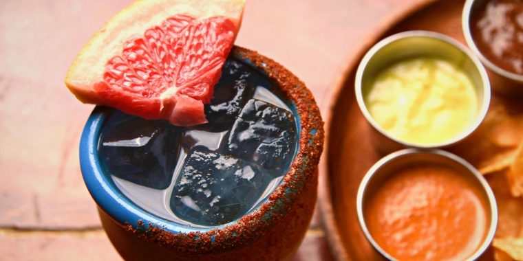 Cantarito Cocktail served in a clay cup with grapefruit and chili garnish