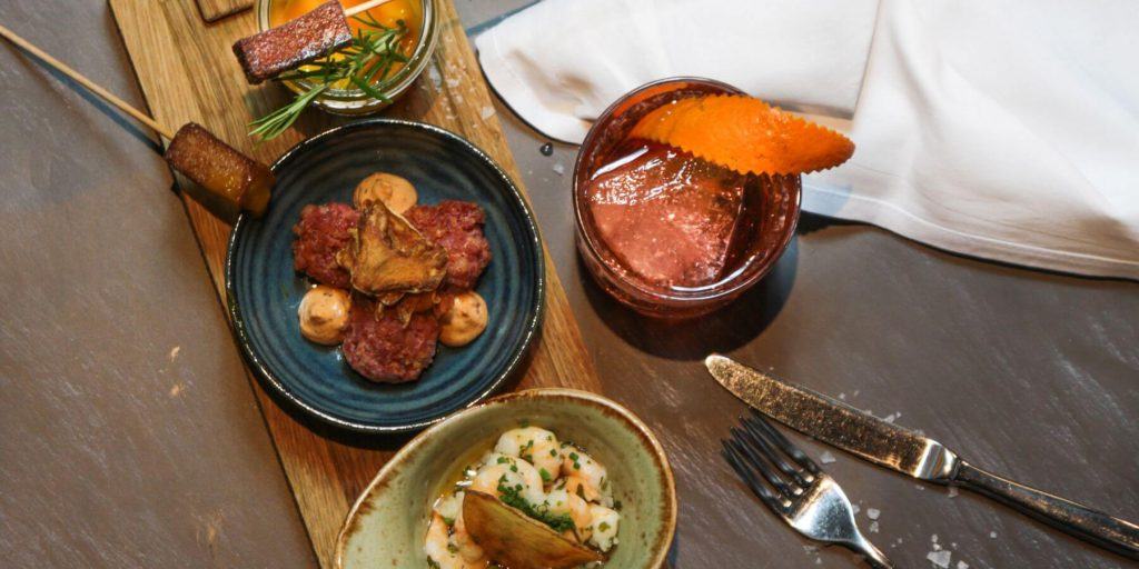 Overhead of small appetizers with Negroni