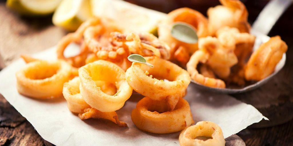 Crispy fried calamari rings on parchment paper