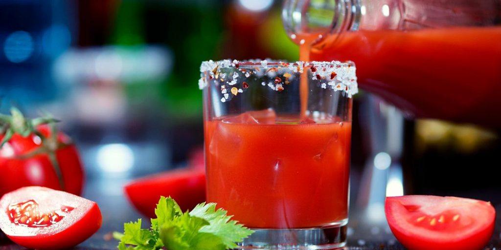 Front view of tomato juice being poured into a glass