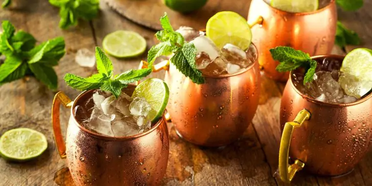 Refreshing mule cocktails in copper mugs with lime and mint garnish