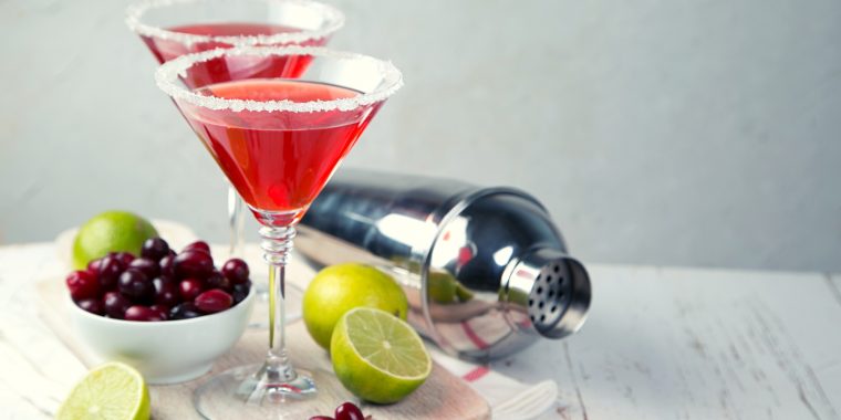 Two bright red Cranberry Martinis with lime and fresh cranberries