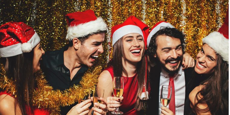 Five friends in Christmas hats celebrating