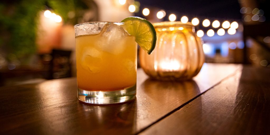 A cognac Margarita cocktail at night on a wooden table