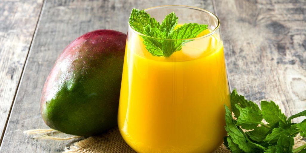 A vibrant Mango Lassi cocktail garnished with fresh mint