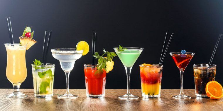 A line up of colourful cocktails in different glasses