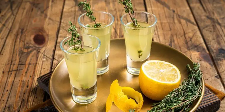 An invigorating Green Tea Shot recipe served up with a thyme garnish for extra flavor