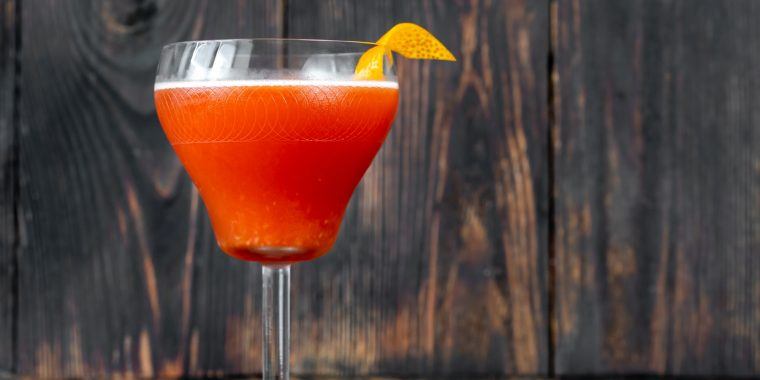 Naked and Famous cocktail garnished with a lemon twist