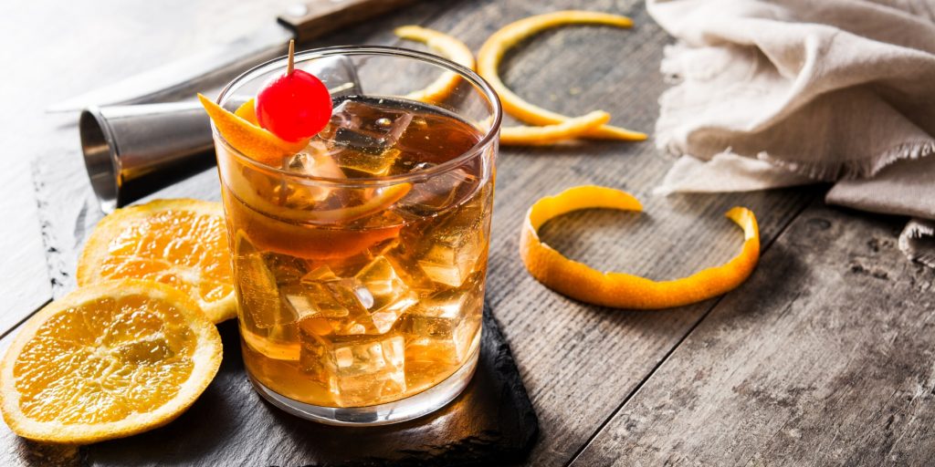 A bourbon Old Fashioned garnished with orange and cherries