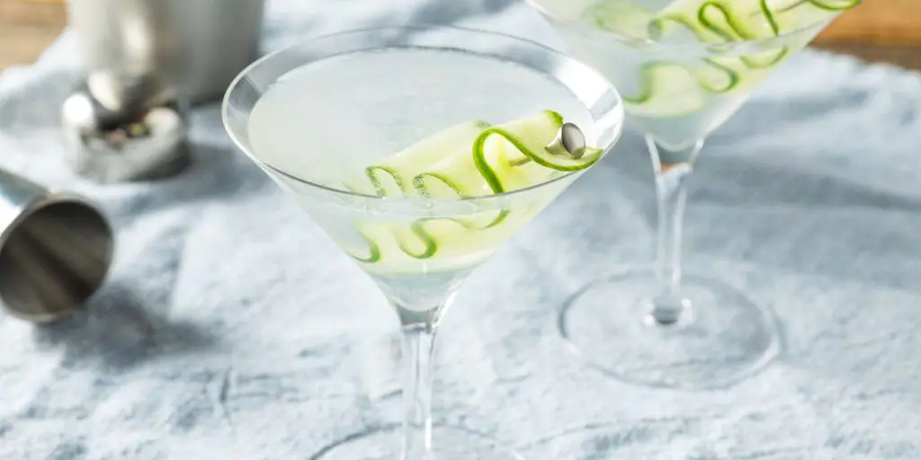 Sauve and sophisticated Saketini cocktail garnished with cucumber ribbons on a cocktail pick